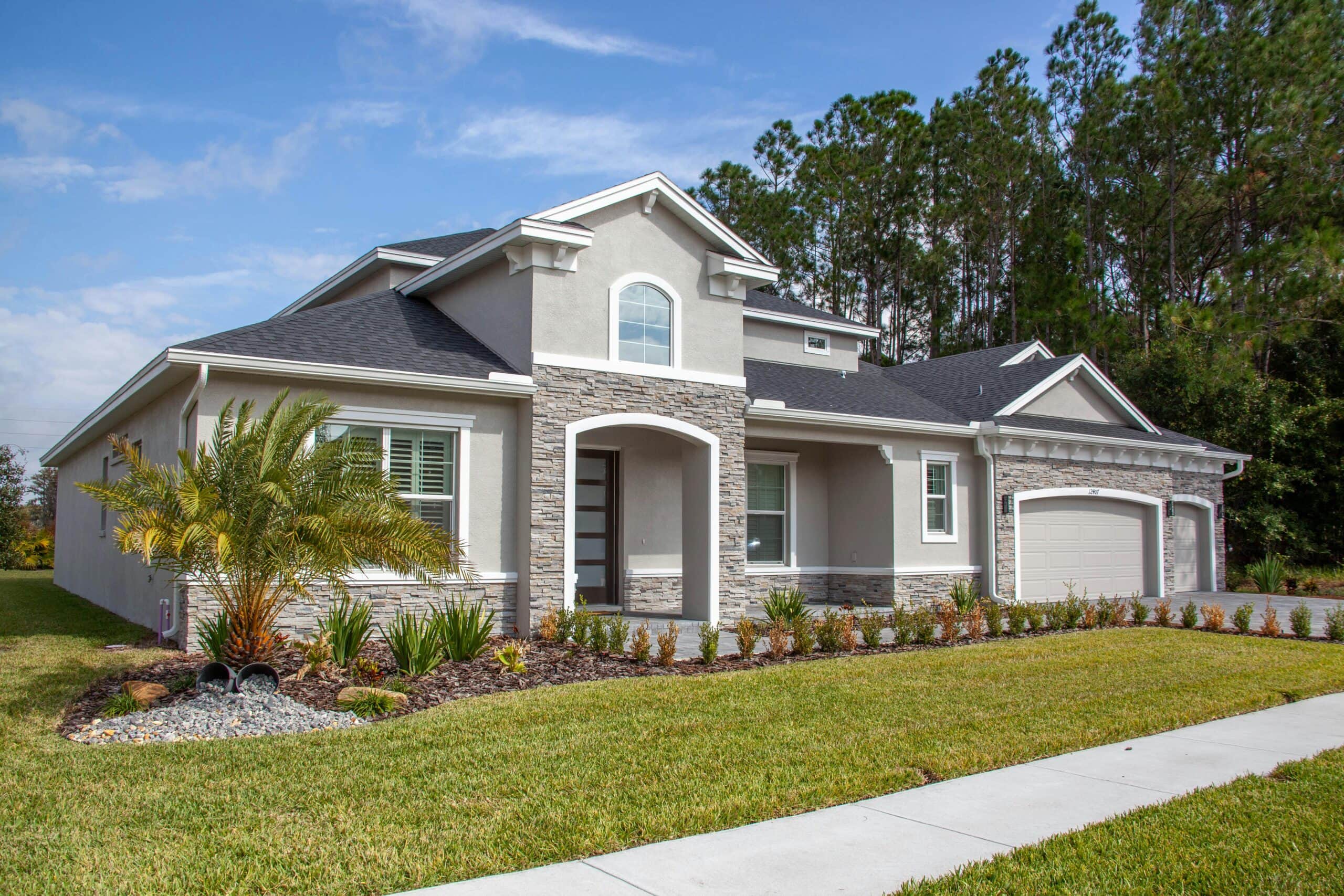 Beautiful modern suburban house in Odessa, FL with lush garden and clear blue sky.