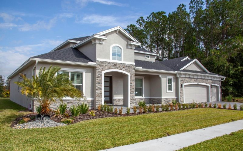 Beautiful modern suburban house in Odessa, FL with lush garden and clear blue sky.